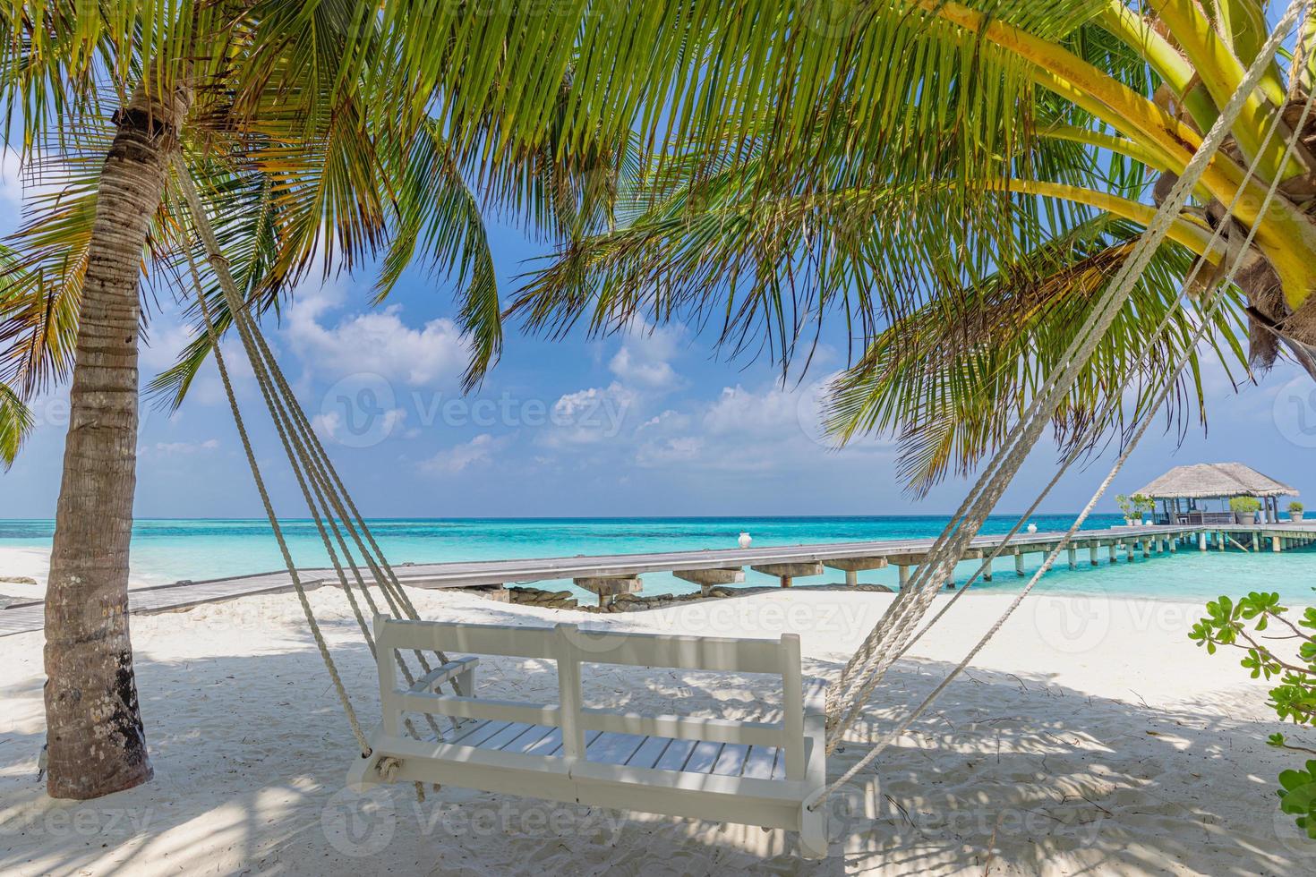 tropisches strandpanorama als sommerlandschaft mit strandschaukel oder hängematte und weißem sand und ruhigem meer für strandbanner. perfektes strandszenenurlaubs- und sommerferienkonzept. Verbessern Sie den Farbprozess foto