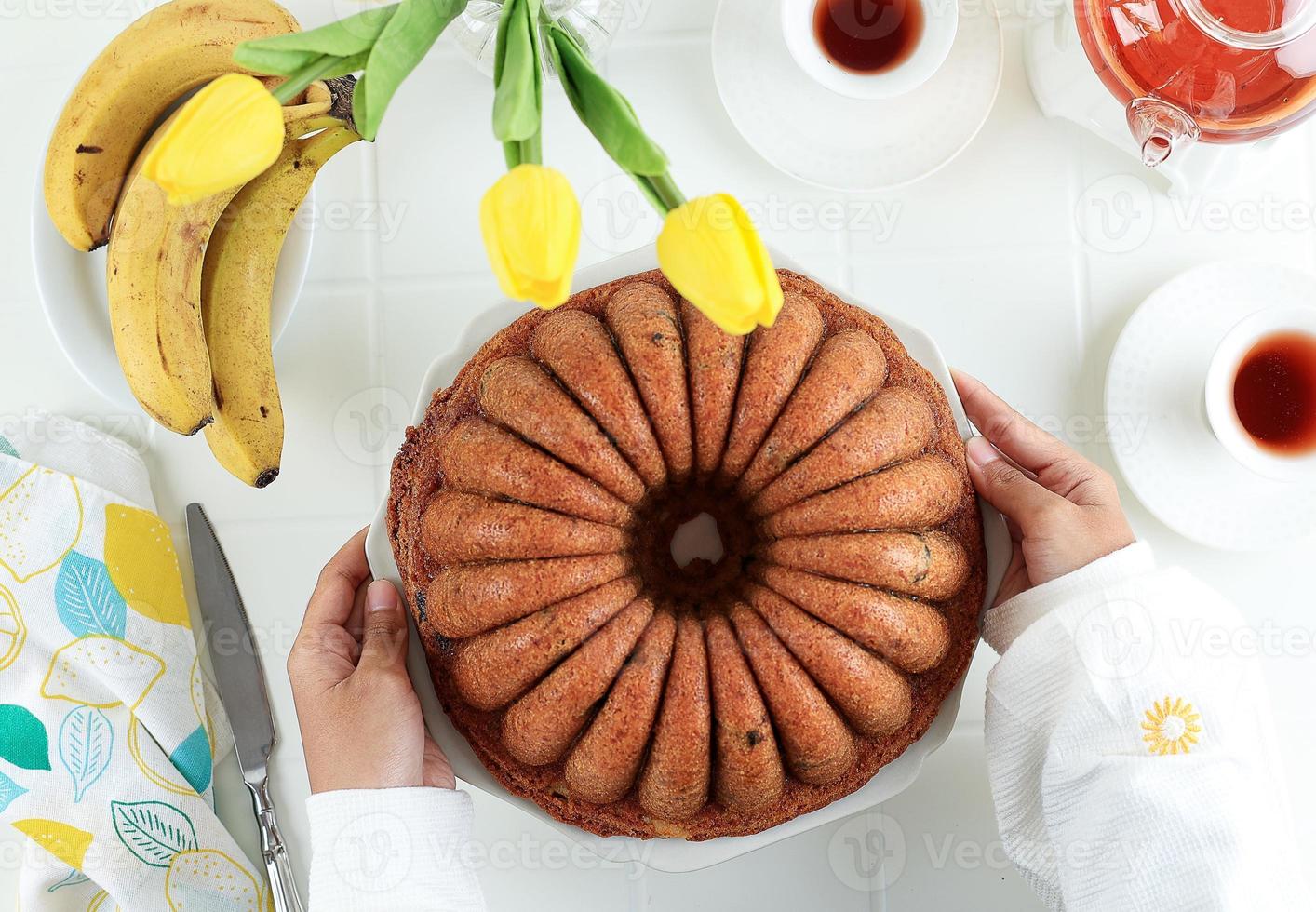 draufsicht weiblicher handgriff großer teller mit bananenbundt brotkuchen foto