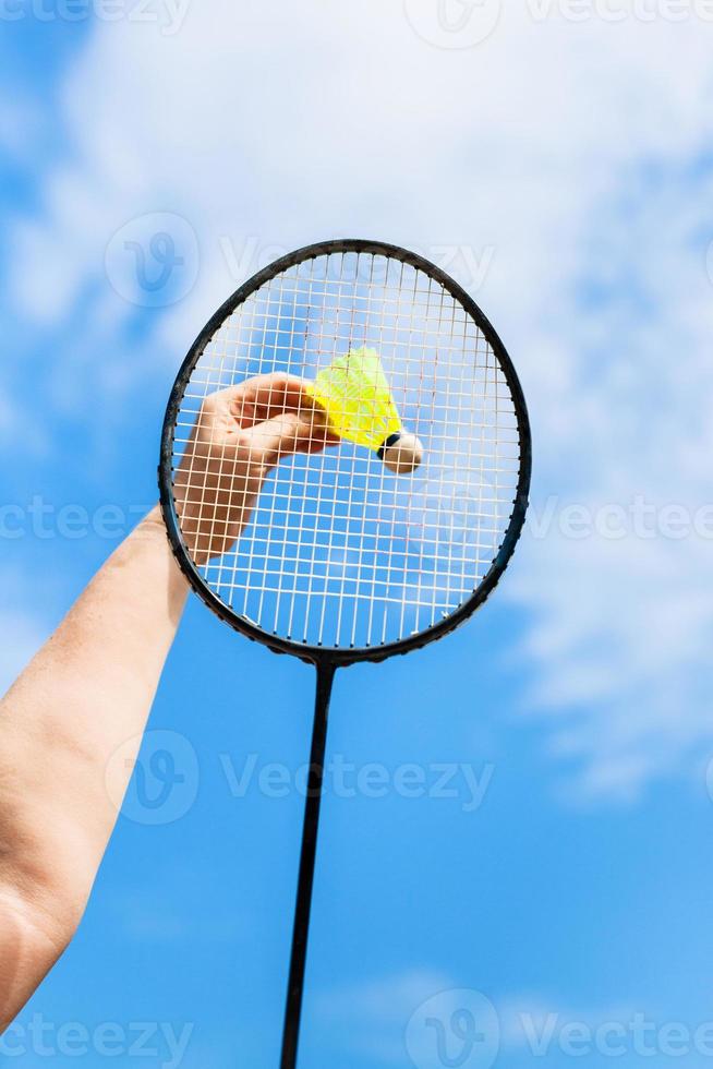 weibliche Hand trifft Federball mit Badmintonschläger foto