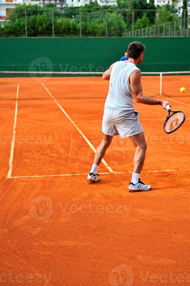mann spielt tennis im freien foto