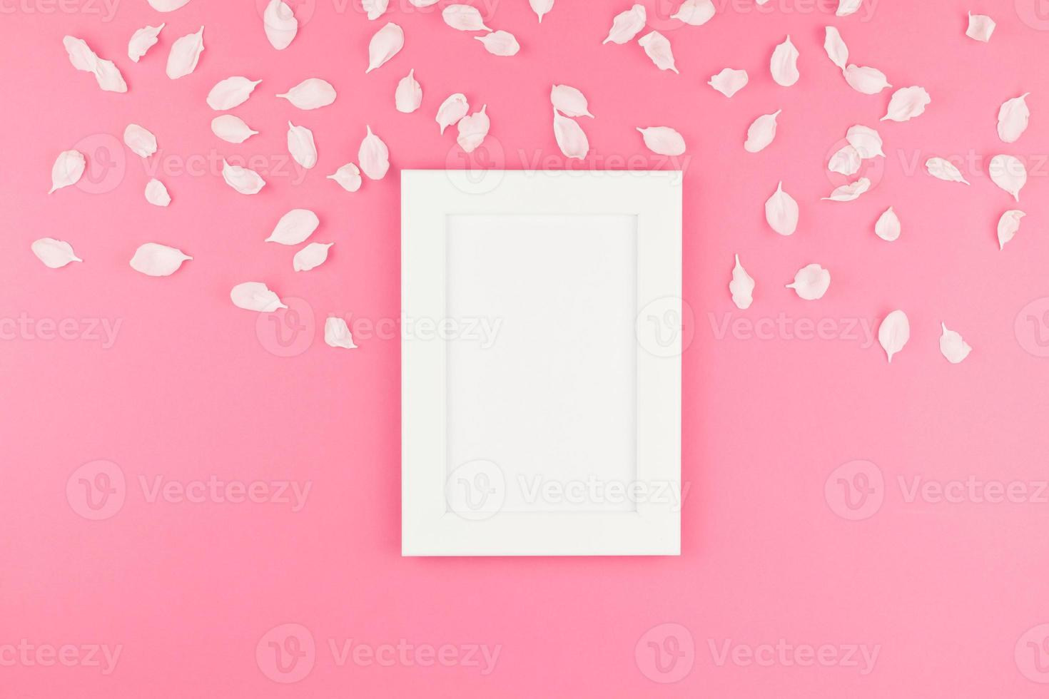 flache lage aus weißem rahmen mit blütenblättern foto