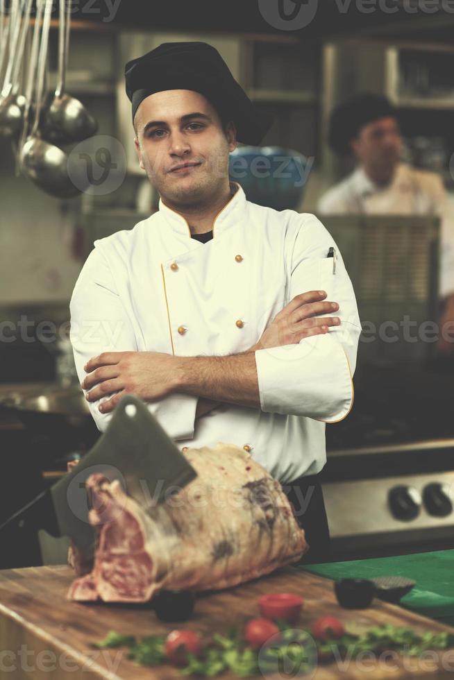 Koch schneidet ein großes Stück Rindfleisch foto