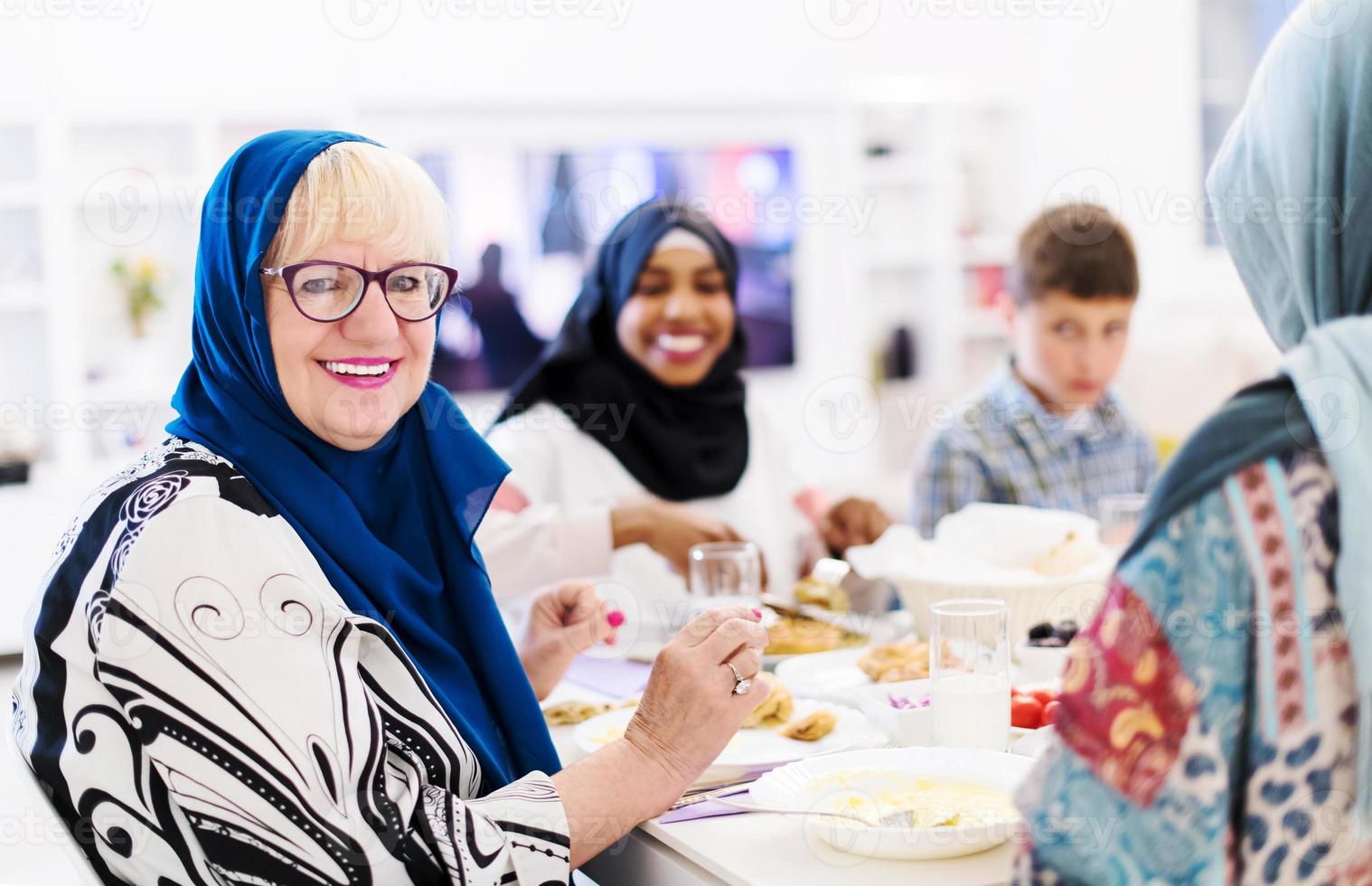 moderne muslimische großmutter, die iftar-abendessen mit der familie genießt foto