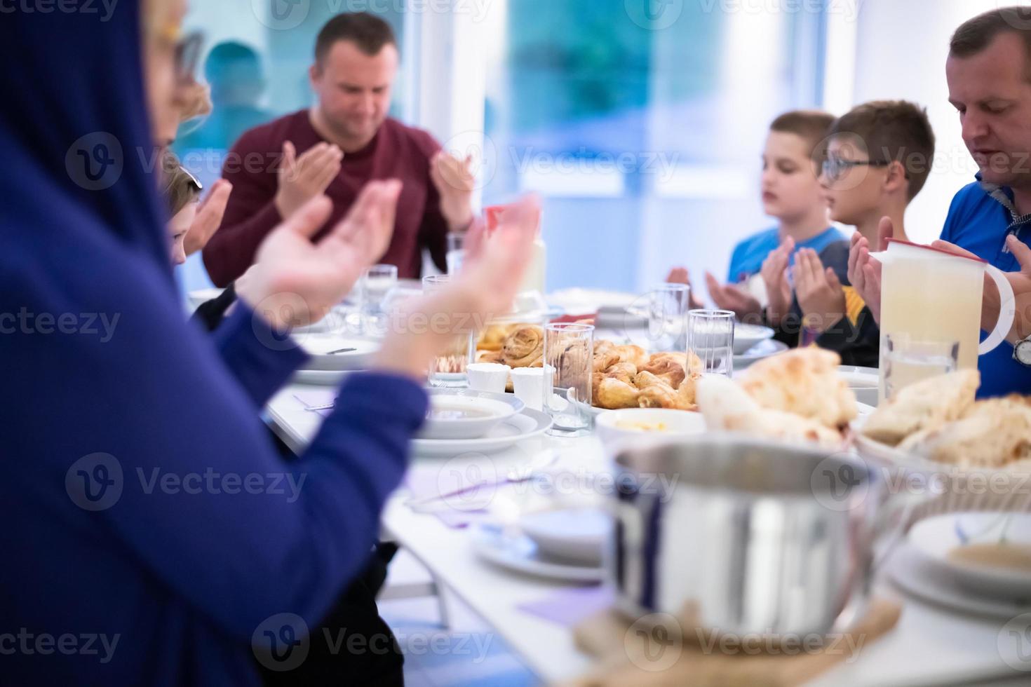 eid mubarak islamische familie, die vor halal iftar-abendessen betet foto