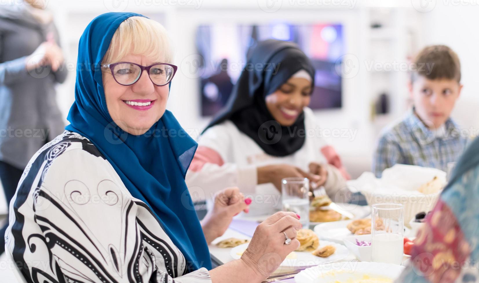 moderne muslimische großmutter, die iftar-abendessen mit der familie genießt foto