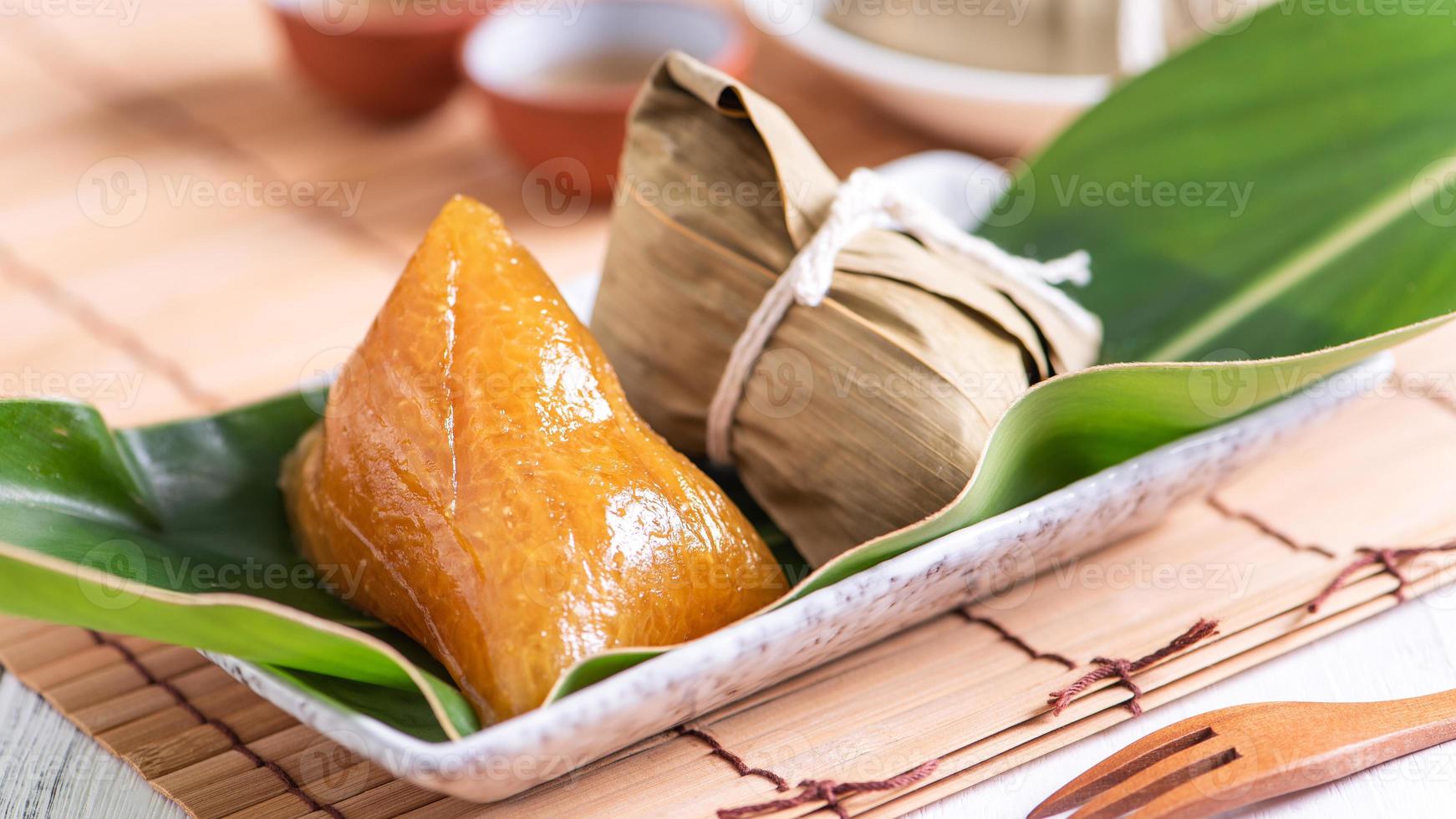 zongzi - basischer reisknödel - traditionelles süßes chinesisches kristallessen auf einem teller zum essen für drachenboot duanwu festivalfeierkonzept, nahaufnahme. foto