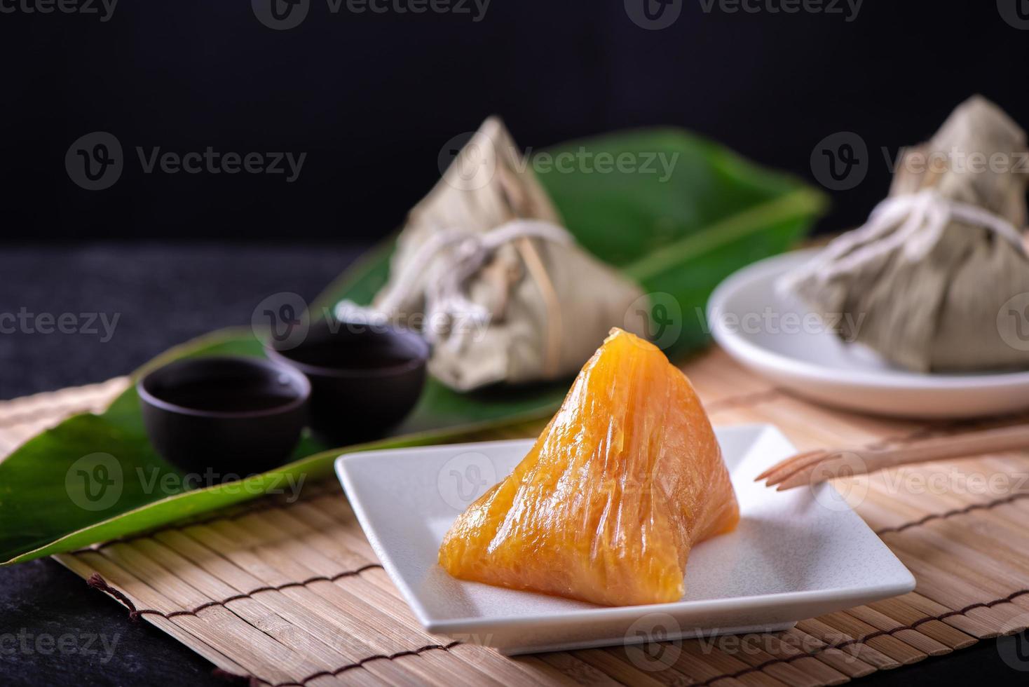 basischer reisknödel zongzi - traditionelles süßes chinesisches kristallessen auf einem teller zum essen für das drachenboot duanwu festivalfeierkonzept, nahaufnahme. foto