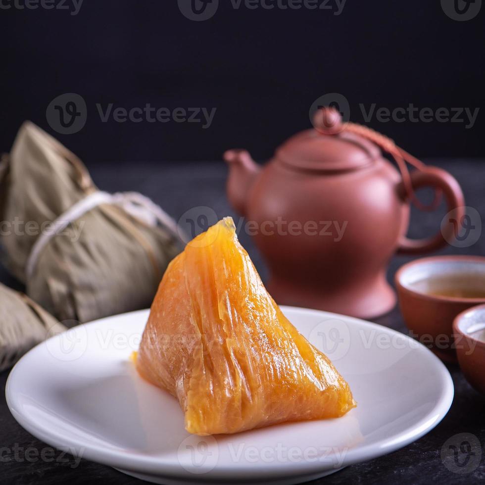 basischer reisknödel zongzi - traditionelles süßes chinesisches kristallessen auf einem teller zum essen für das drachenboot duanwu festivalfeierkonzept, nahaufnahme. foto