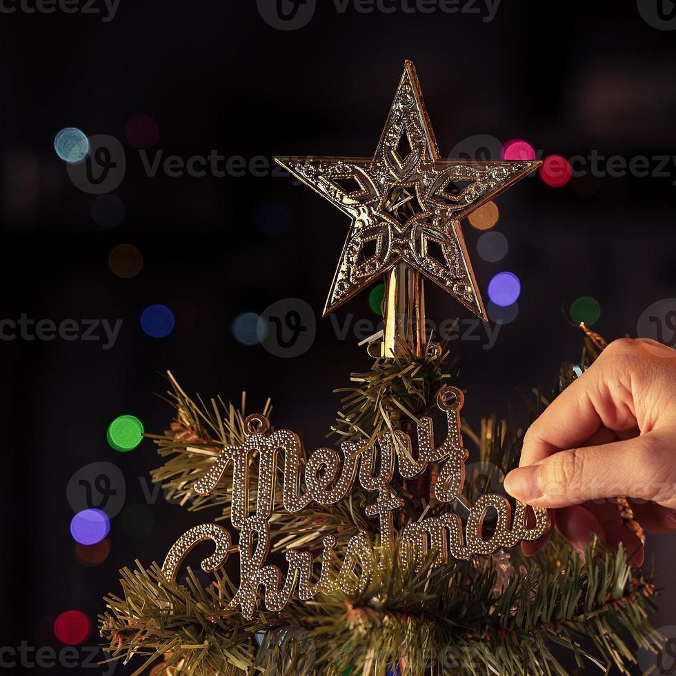 weihnachtshintergrundkonzept - schöne dekorkugel, die am weihnachtsbaum hängt, mit funkelndem lichtfleck, verschwommenem dunkelschwarzem hintergrund, kopierraum, nahaufnahme. foto