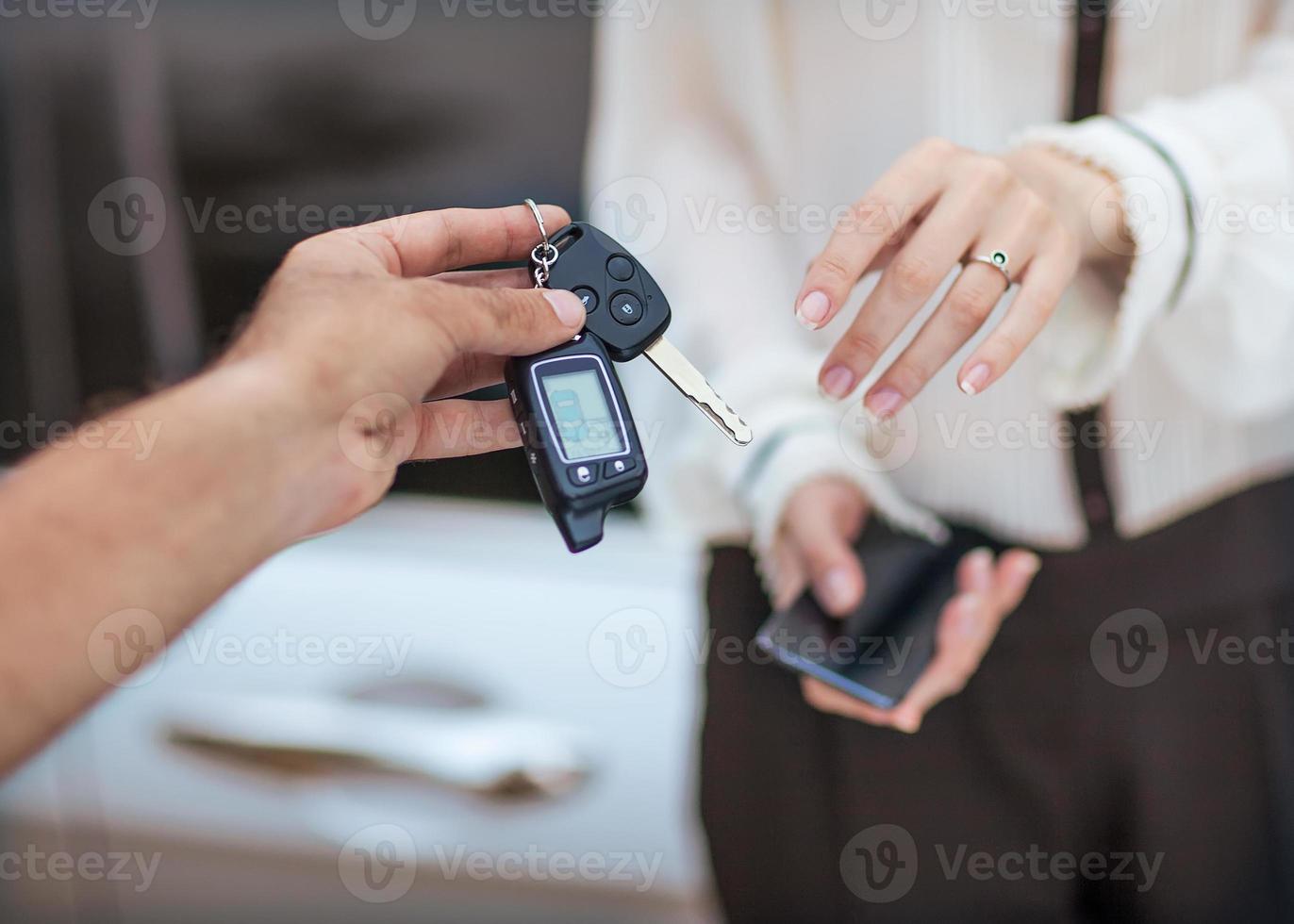 männliche Hand, die Autoschlüssel zur weiblichen Hand gibt. foto