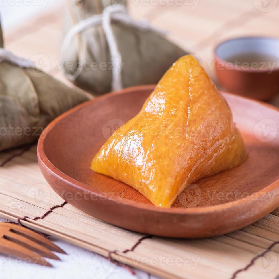 zongzi - basischer reisknödel - traditionelles süßes chinesisches kristallessen auf einem teller zum essen für drachenboot duanwu festivalfeierkonzept, nahaufnahme. foto