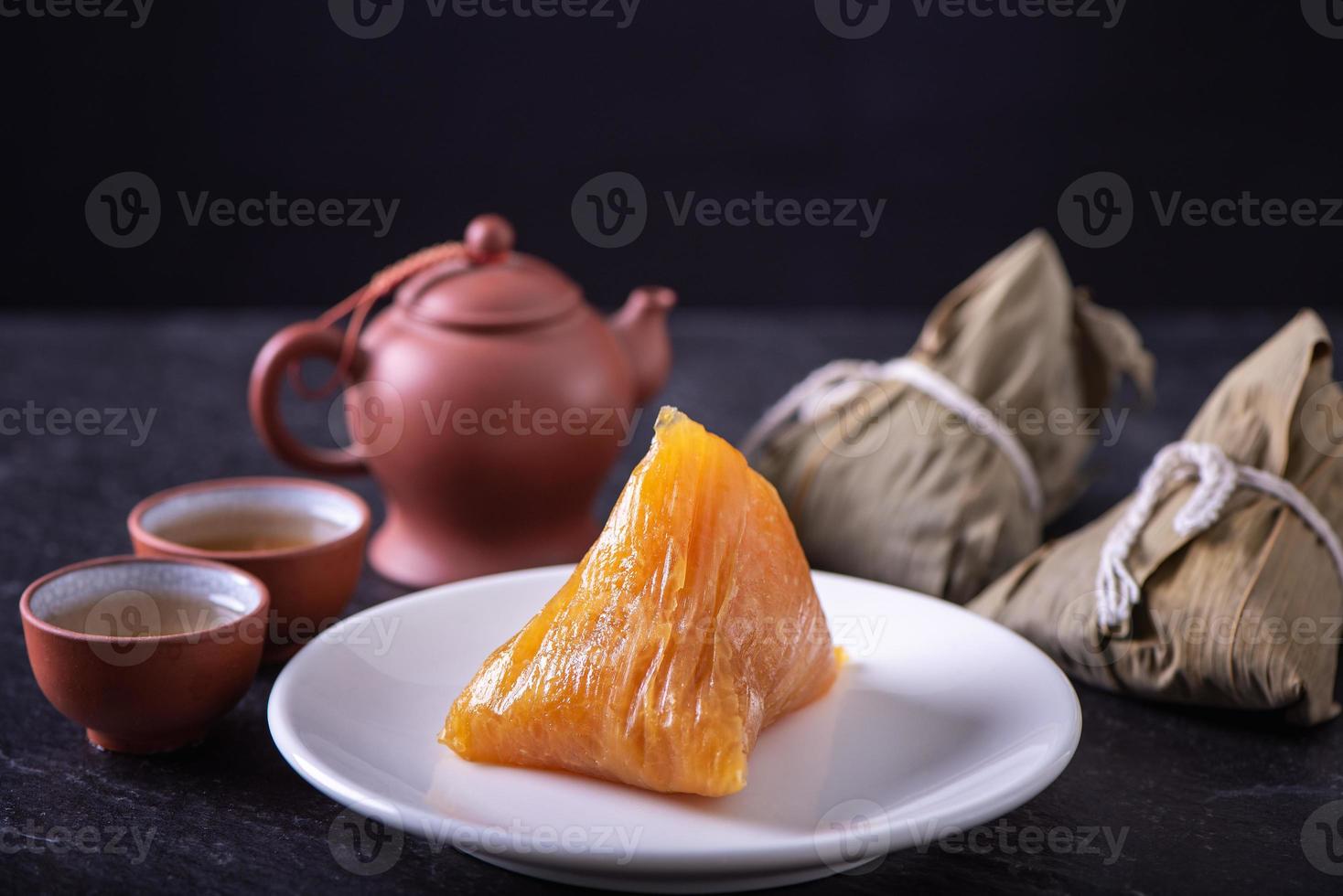 basischer reisknödel zongzi - traditionelles süßes chinesisches kristallessen auf einem teller zum essen für das drachenboot duanwu festivalfeierkonzept, nahaufnahme. foto