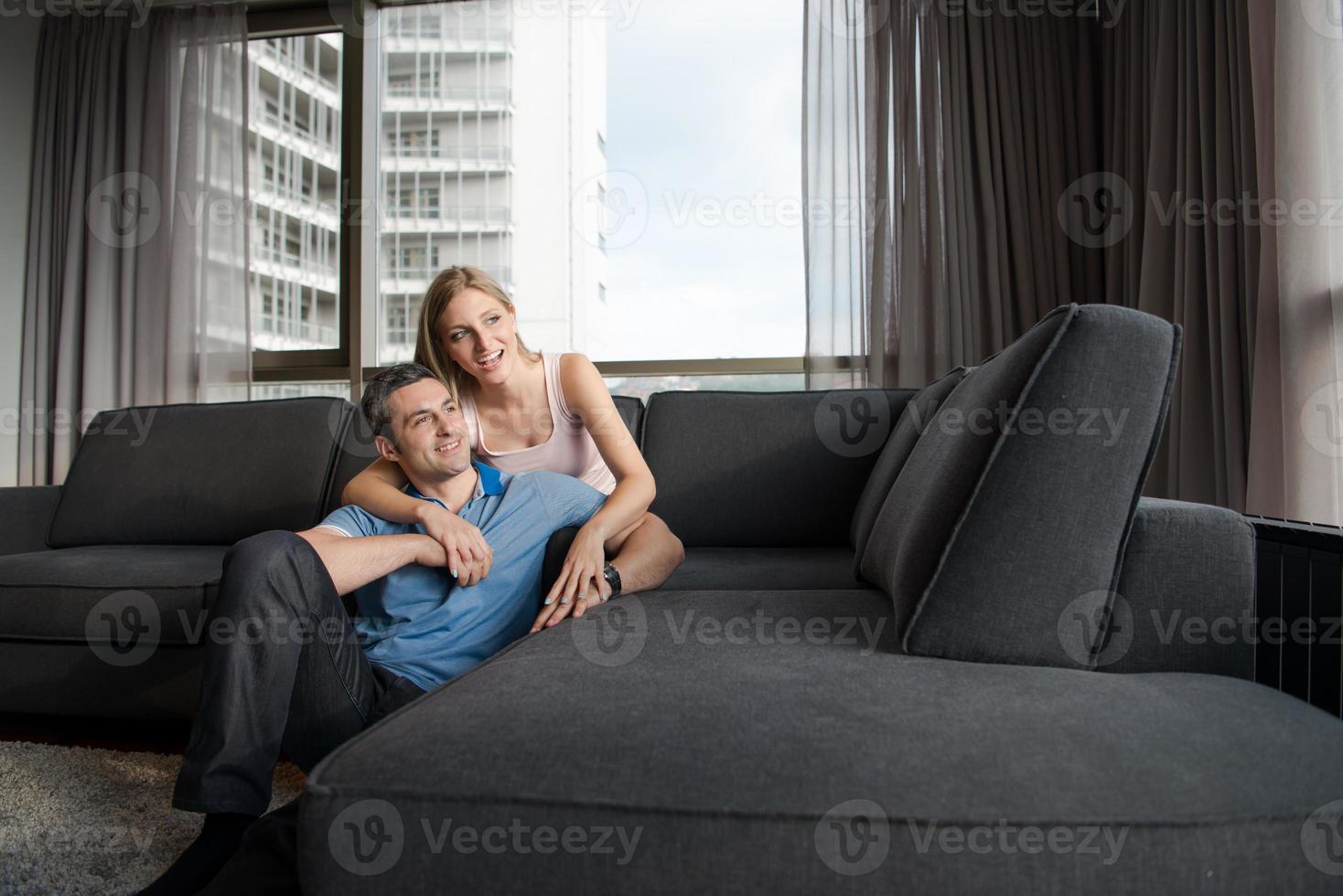 junges hübsches paar, das sich auf dem sofa umarmt foto