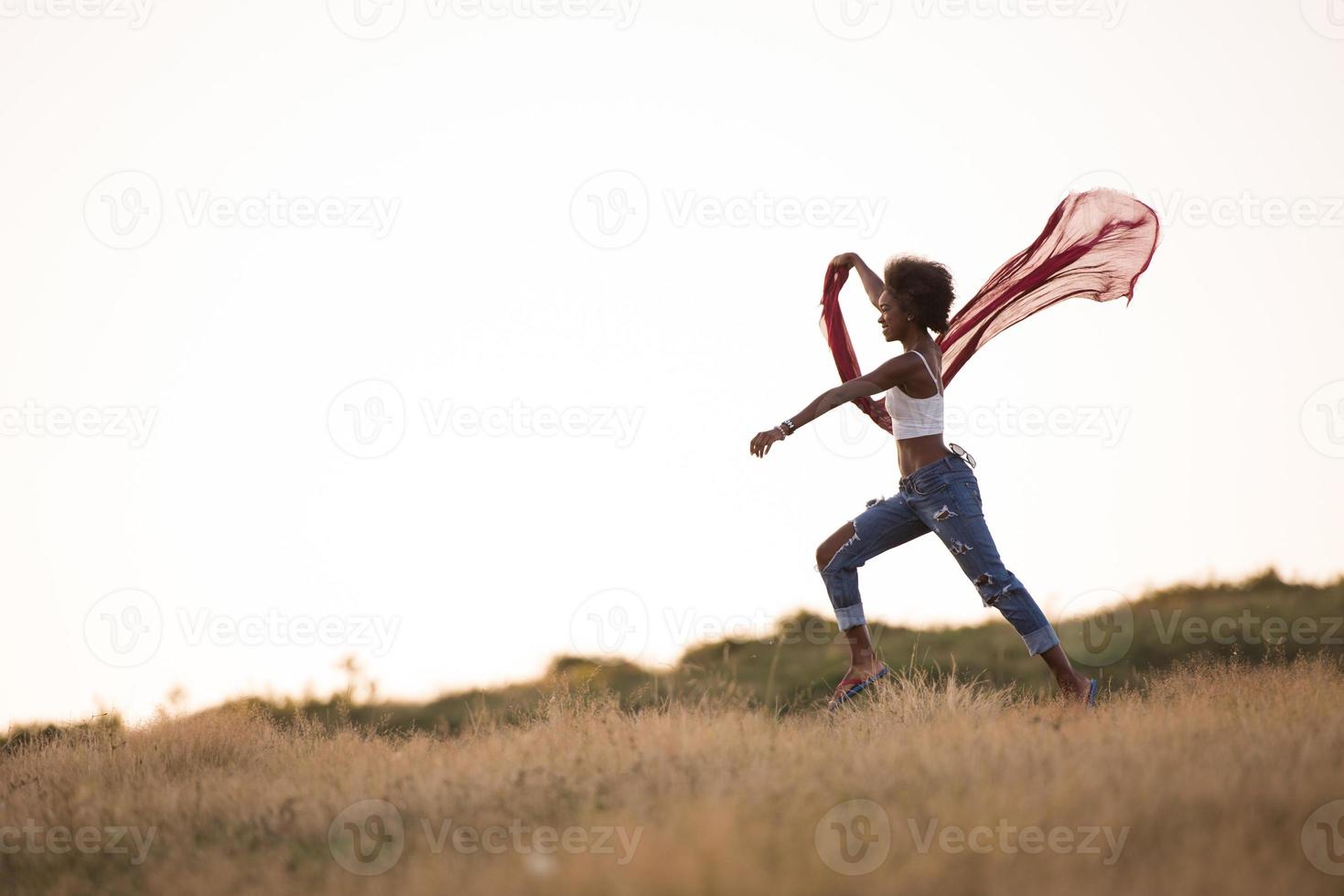Schwarzes Mädchen tanzt draußen auf einer Wiese foto