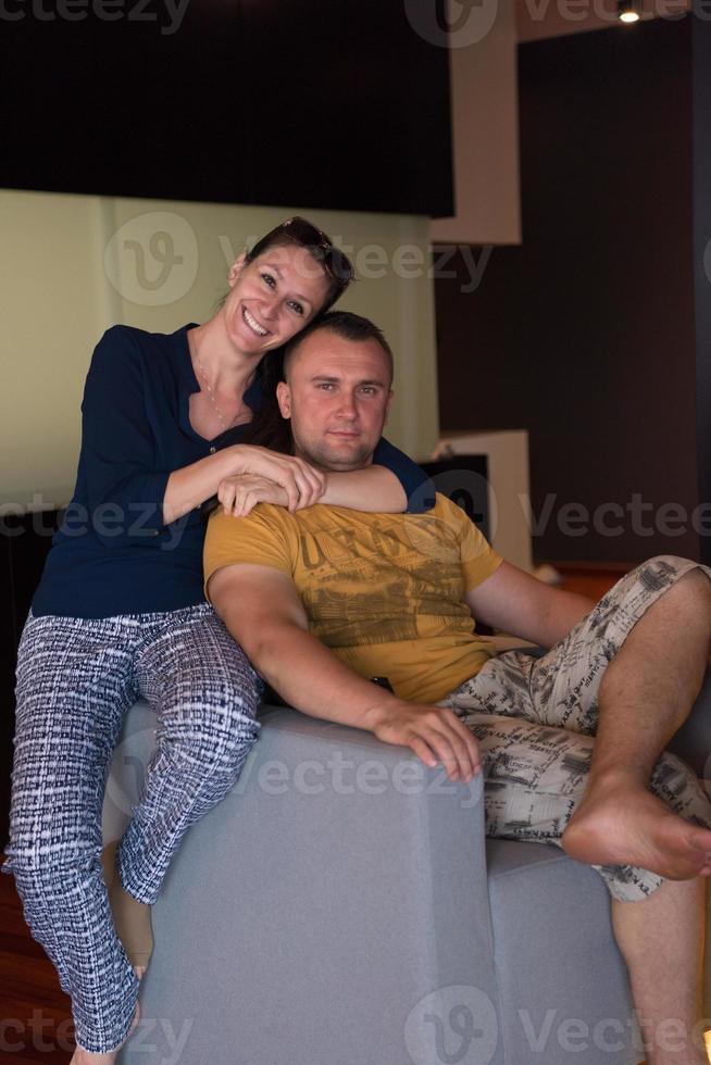 junges hübsches paar, das sich auf dem sofa umarmt foto