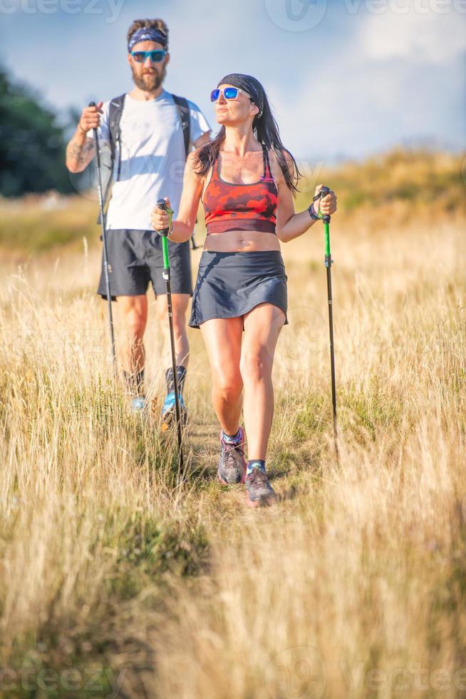 sportliches Paar praktiziert Nordic Walking foto