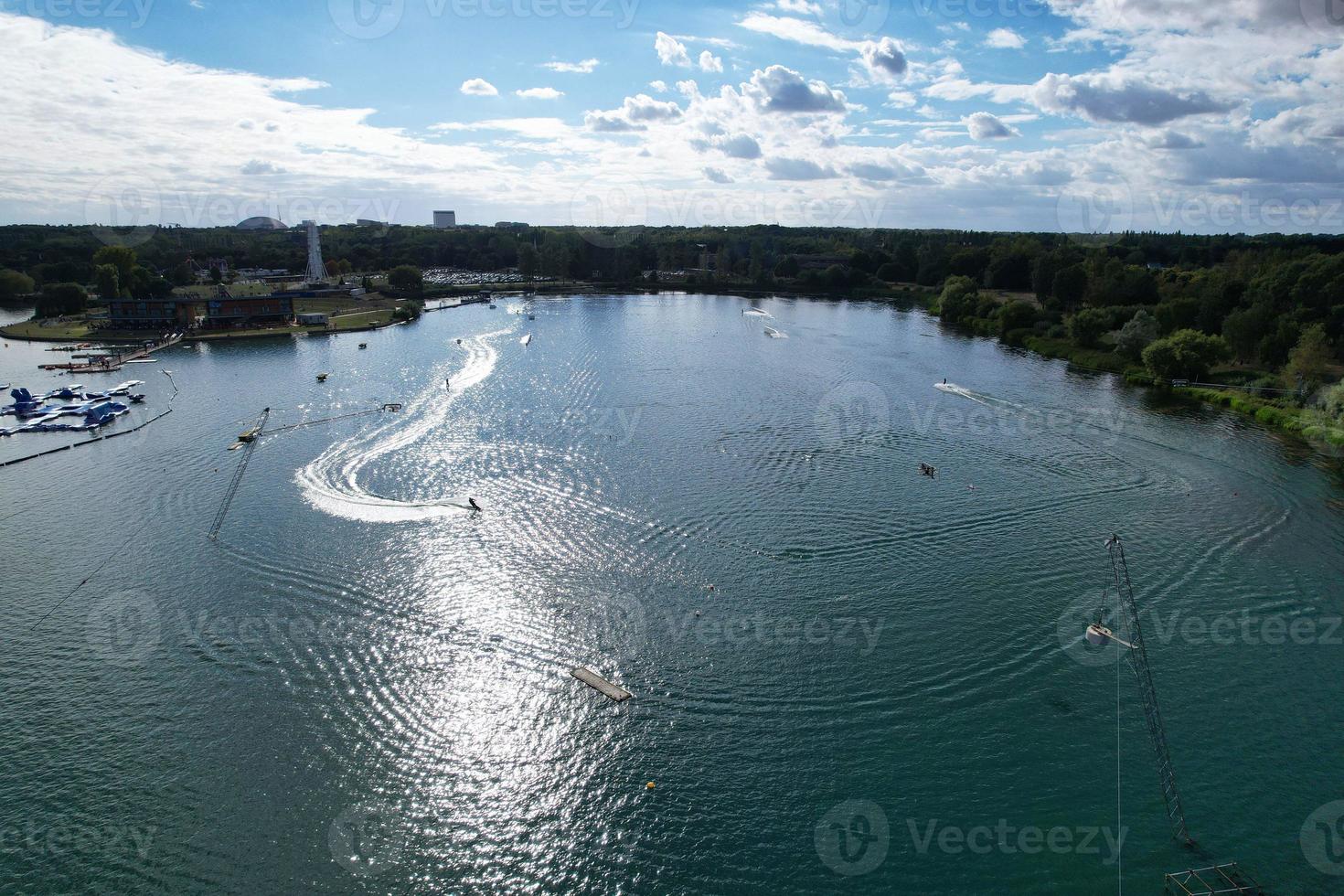 Kameraaufnahmen einer wunderschönen Luftdrohne von Willen Lake und Park, der sich in Milton Keynes, England, befindet. Die Menschen genießen an einem heißen sonnigen Sommertag am See foto