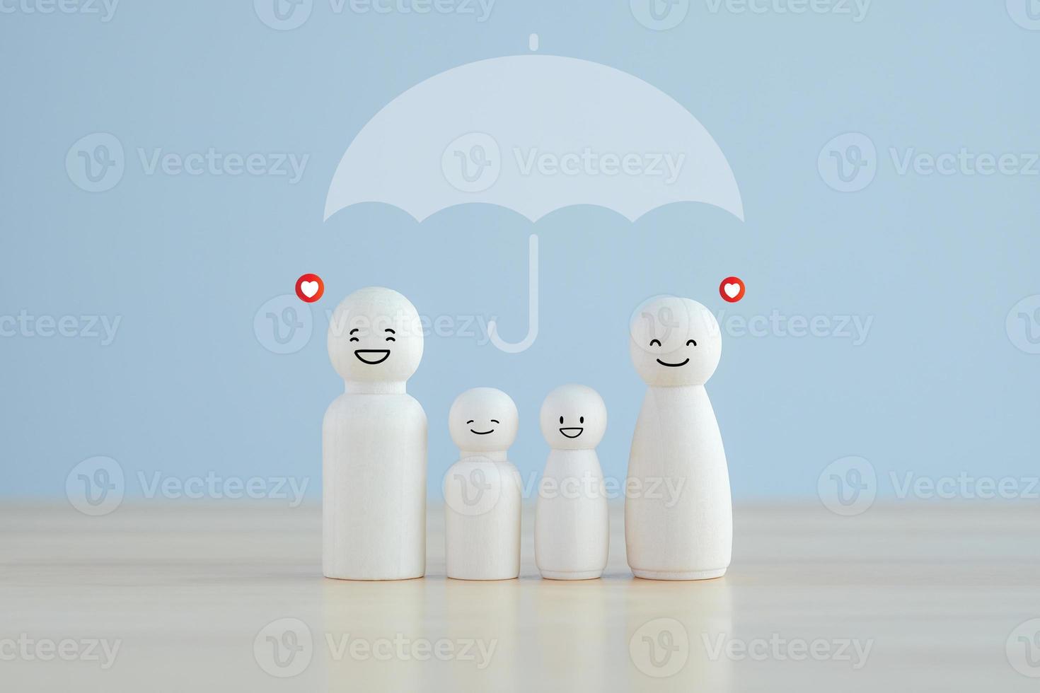 Lebens- und Krankenversicherung. regenschirm schützendes holzmodell der familie für das versicherungslebenskonzept. foto