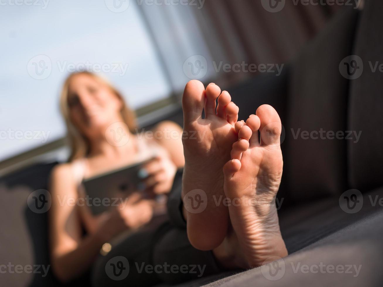 Frau mit Tablet auf der Couch zu Hause foto