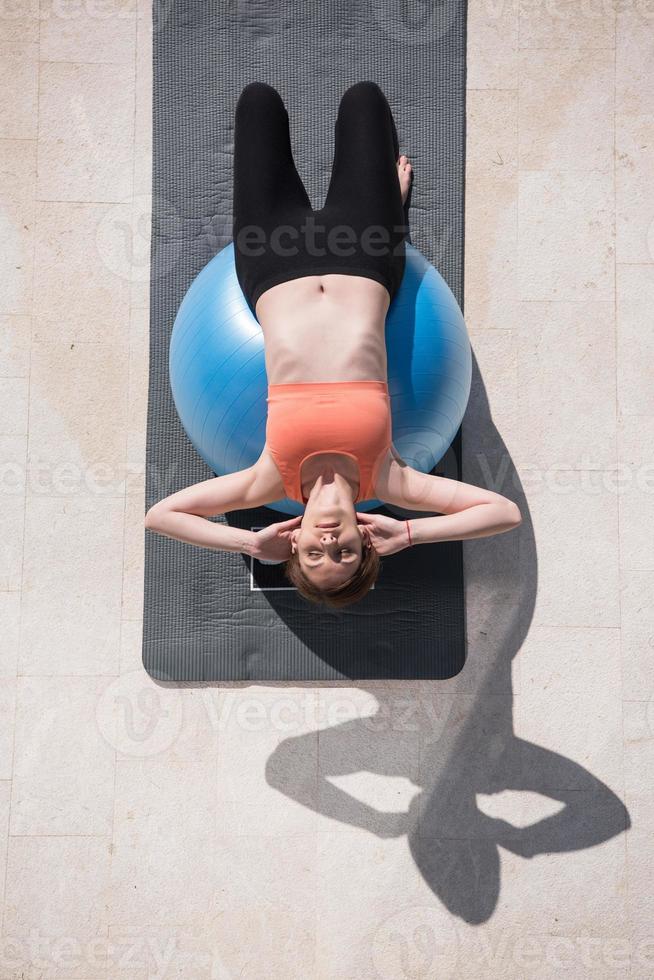 frau, die übung mit pilates-ball-draufsicht tut foto