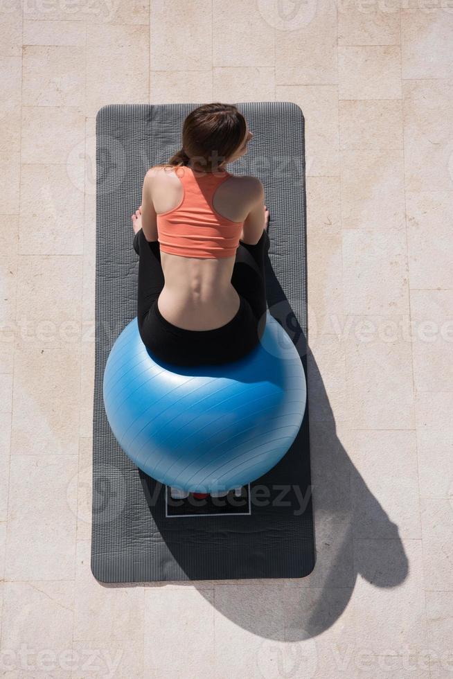 frau, die übung mit pilates-ball-draufsicht tut foto