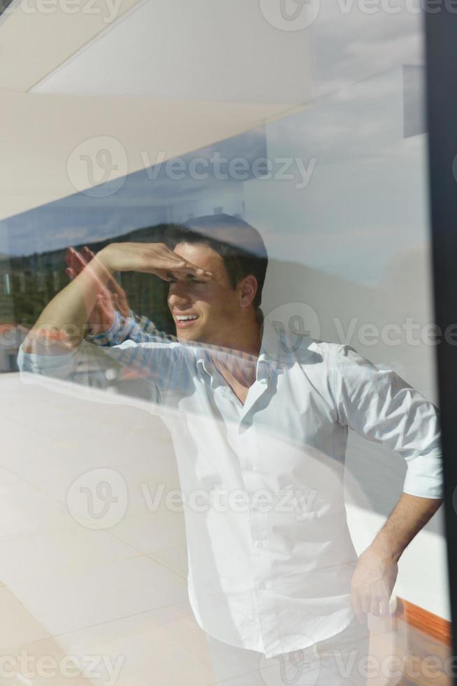 Entspannter junger Mann zu Hause auf dem Balkon foto