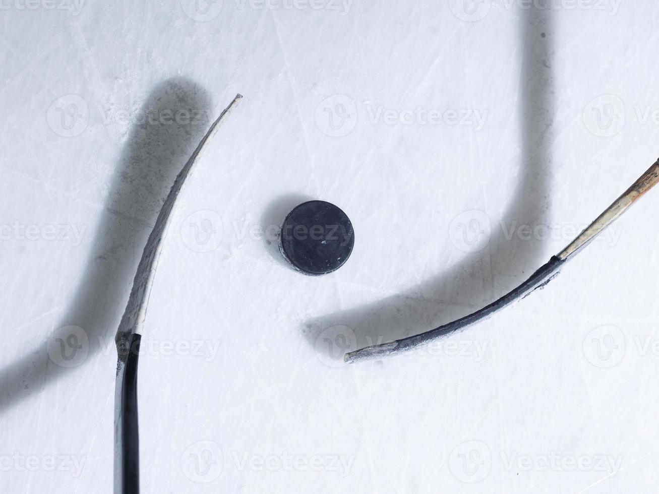 Hockeyschläger und Puck auf Eis foto