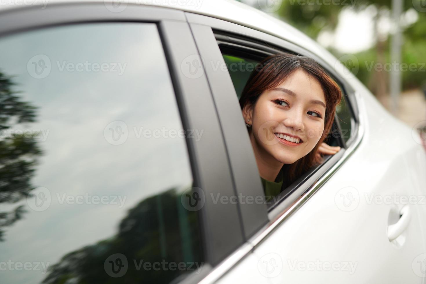 junge weibliche Passagierin lehnte sich lächelnd aus dem Fenster foto