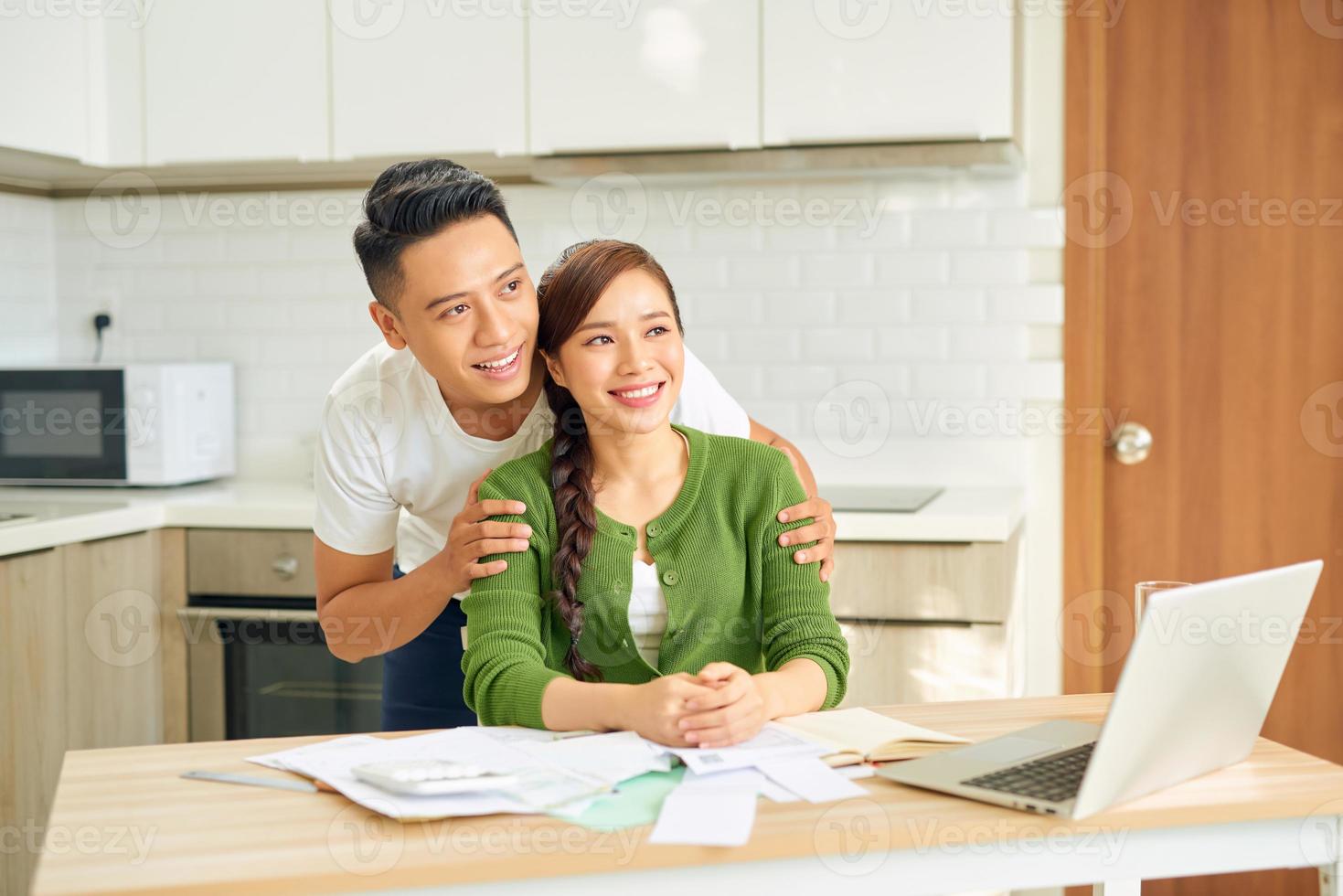 glückliches Paar mit einem Notebook in ihrer Küche foto