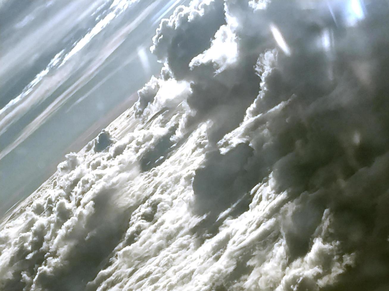 Wolken und Himmelsansicht, wie durch Fenster eines Flugzeugs gesehen foto