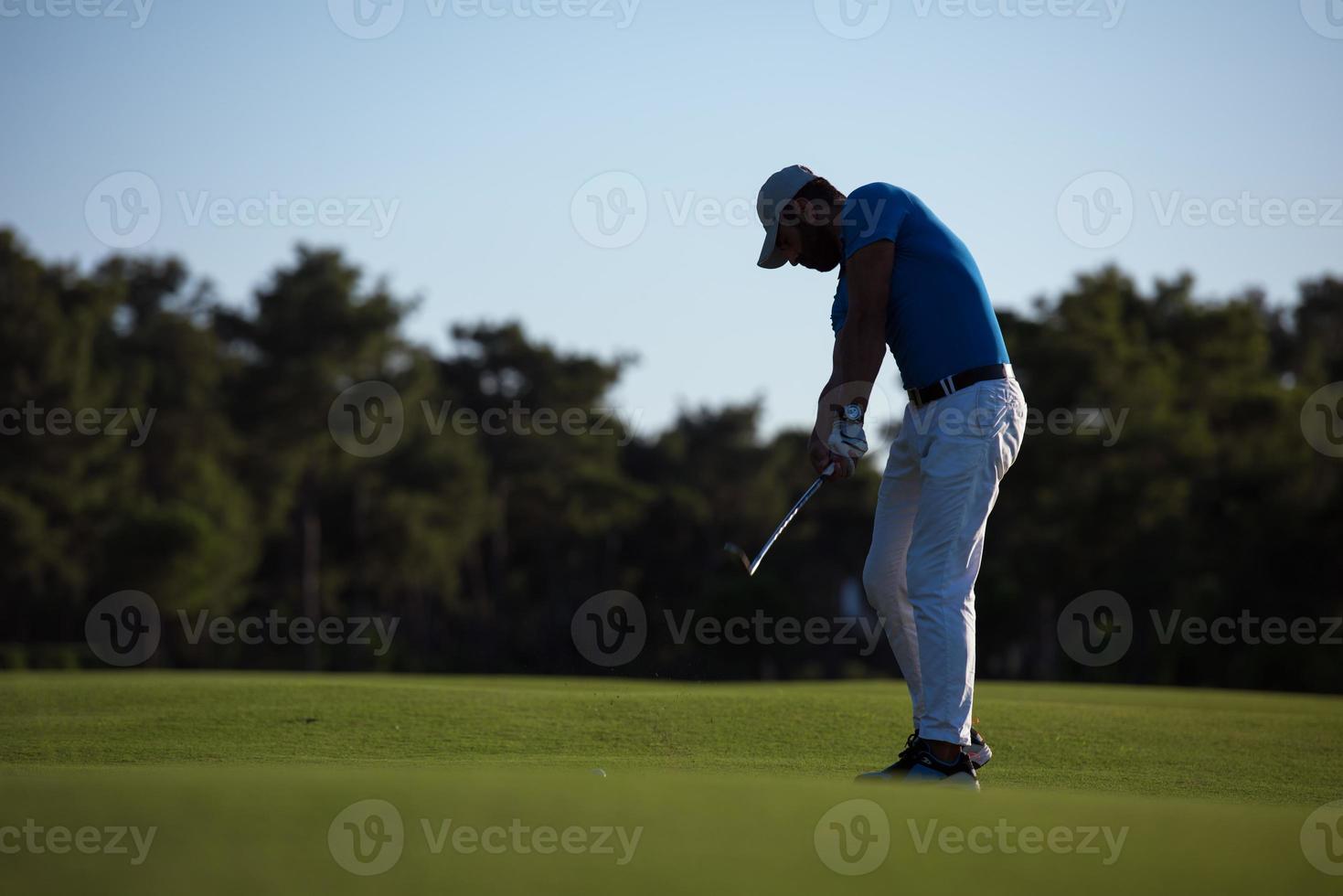 Golfspieler, der einen langen Schuss schlägt foto