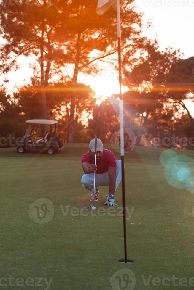 golfspieler, der einen perfekten schuss auf einen wunderschönen sonnenuntergang anstrebt foto