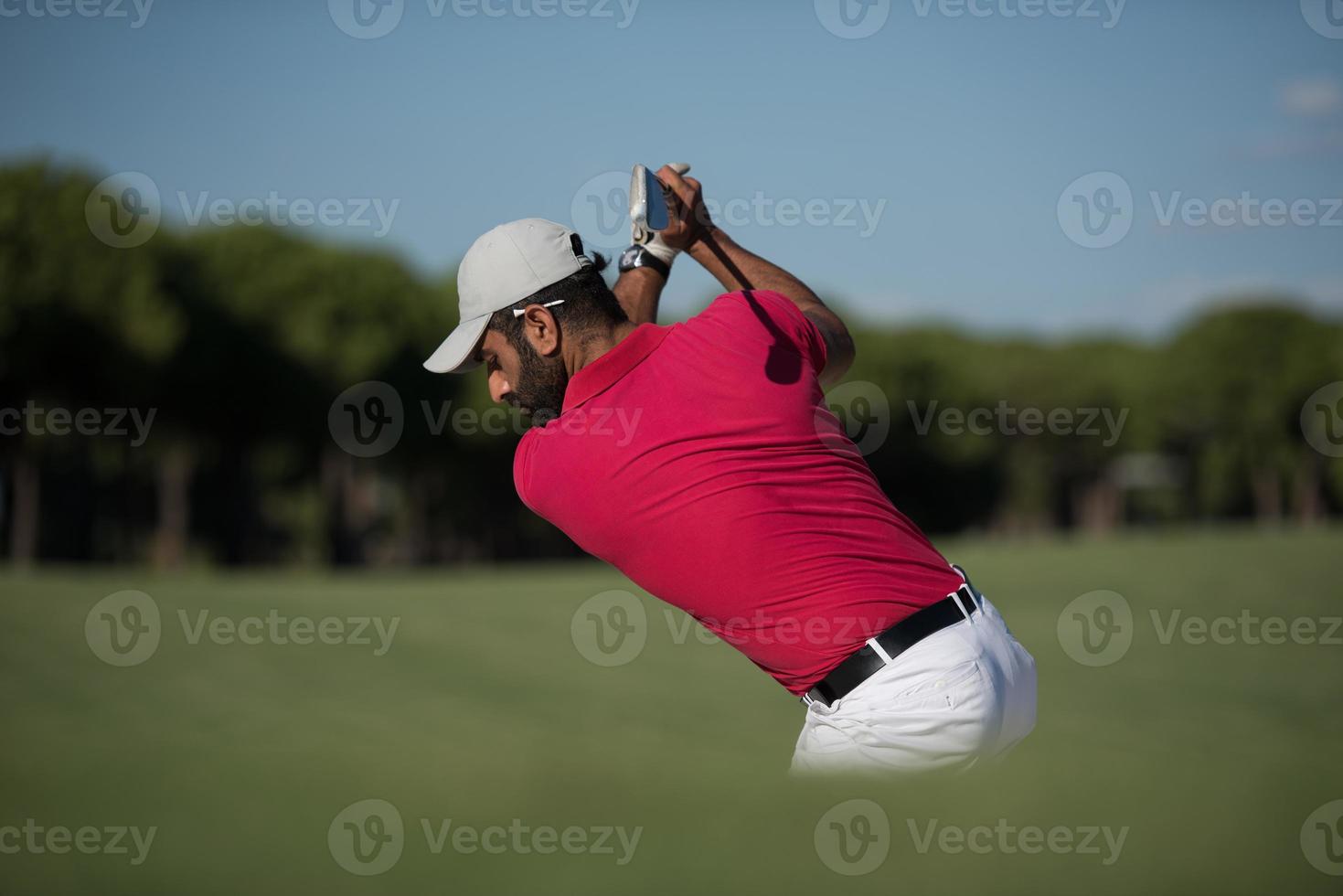 Golfspieler, der einen Sandbunkerschlag schlägt foto