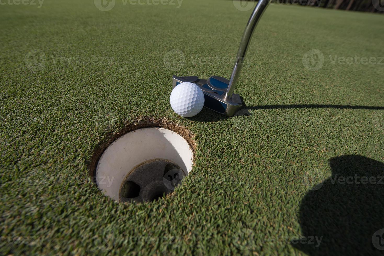 Golfball ins Loch schlagen foto