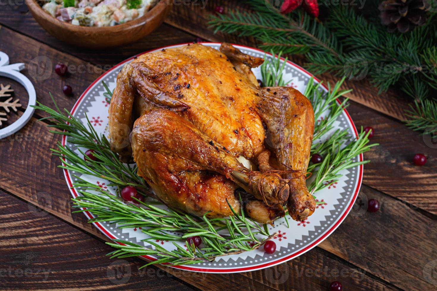 Gebackenes ganzes Huhn oder Truthahn zu Weihnachten. neujahrstisch mit dekoration, hausgemachtem gebratenem huhn, wein und salat foto