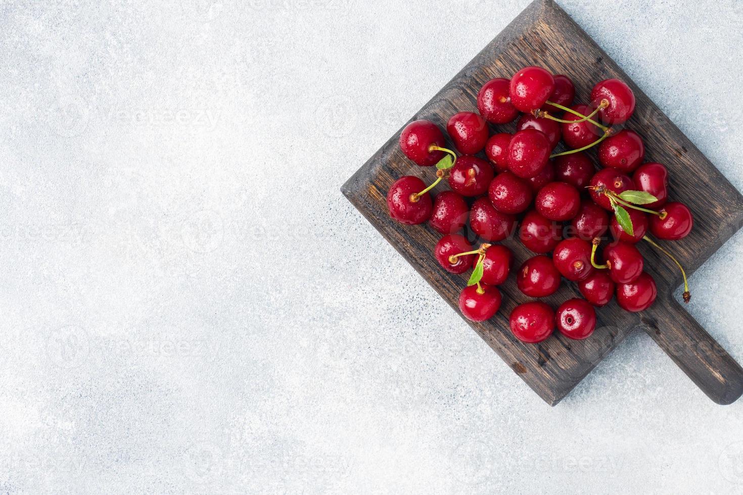 Reife frische Kirschbeeren auf einem Holzschneidebrett. Platz kopieren. foto