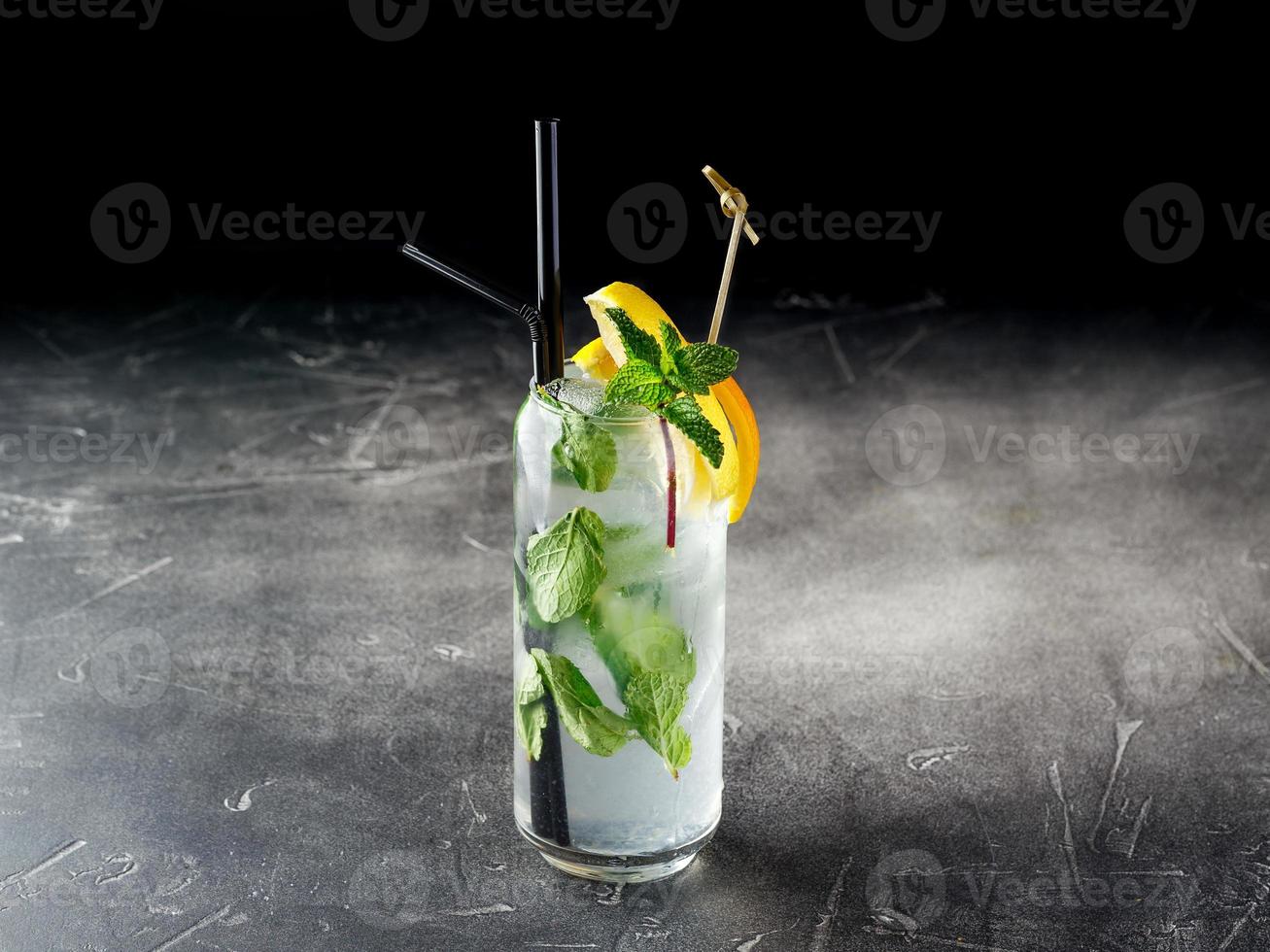 kalter alkoholischer oder alkoholfreier cocktail vom mojito-typ mit eis auf dunklem hintergrund foto