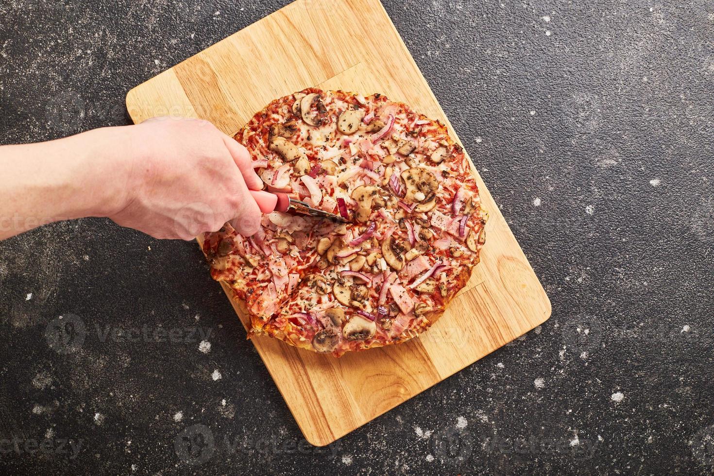 Fast Food, gebackene Tiefkühlpizza mit Schinken, Pilzen und Käse auf dickem Teig. fertig für den Verzehr. foto