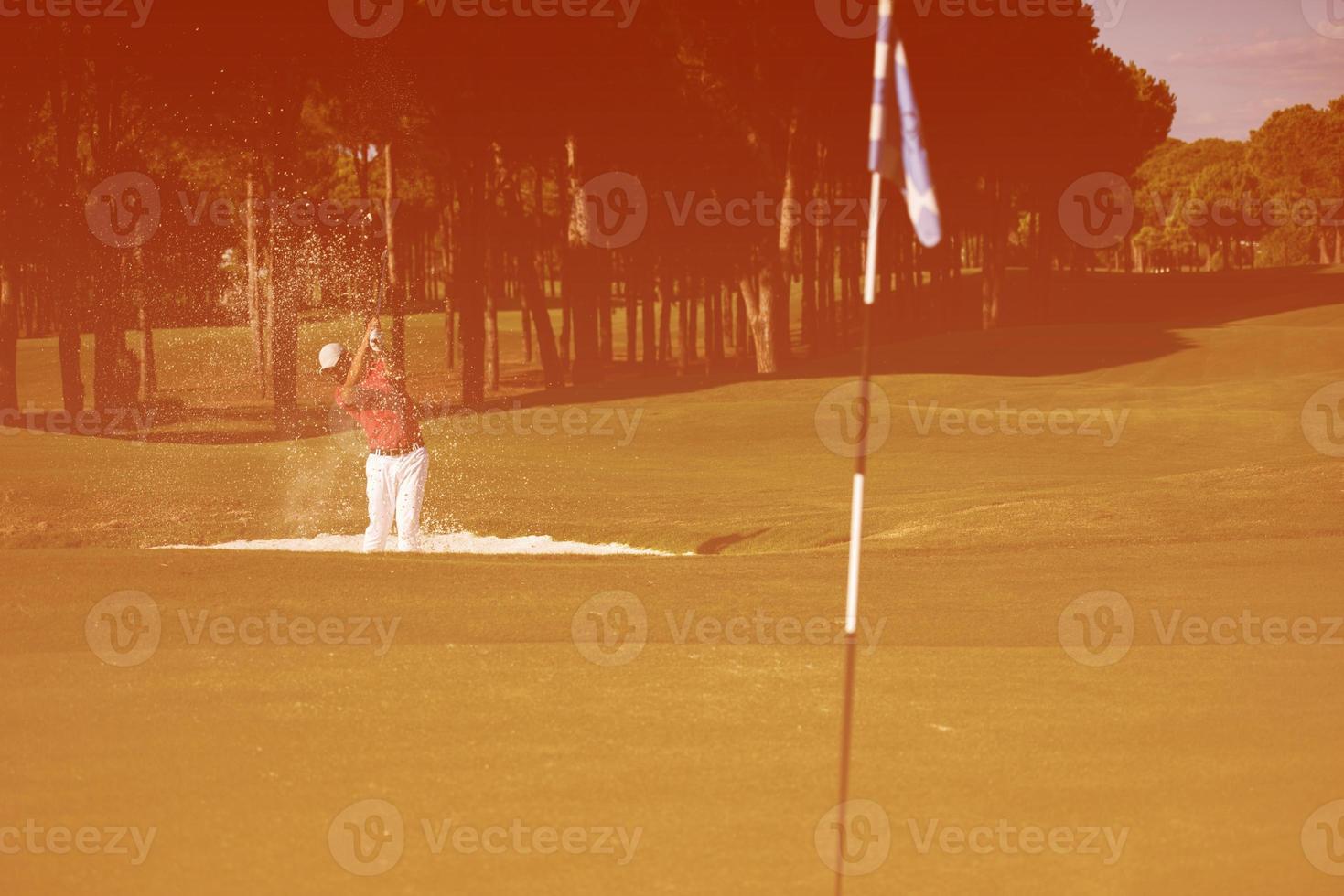 Golfspieler, der einen Sandbunkerschlag schlägt foto