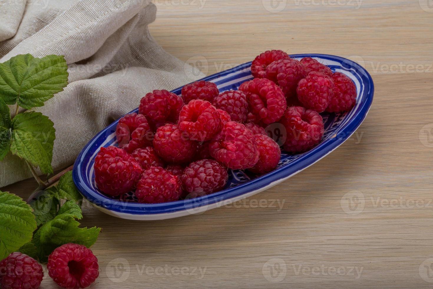 frische Himbeere in einer Schüssel auf hölzernem Hintergrund foto