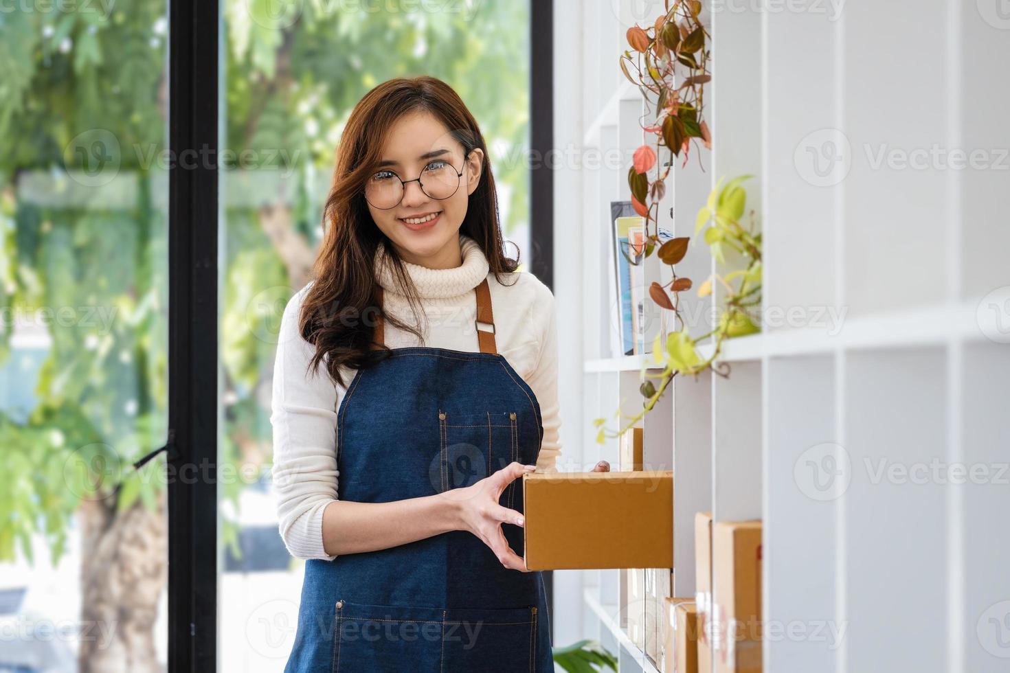 Von zuhause aus arbeiten. Glückliche Frauen, die Produkte online verkaufen, starten Kleinunternehmer, die Paketboxen abholen, um Kundenbestellungen zu verpacken und für den Versand vorzubereiten. foto