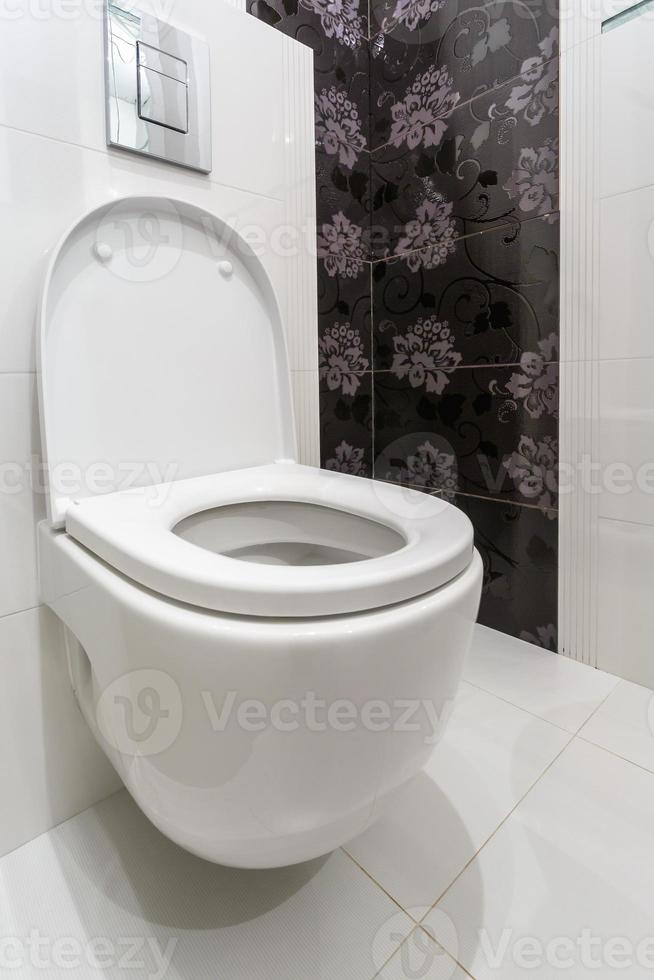 Toilettenschüssel aus weißer Keramik in der Toilette foto