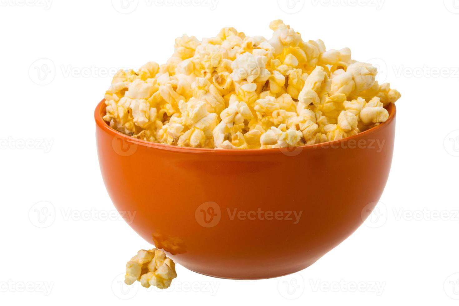 Popcorn in einer Schüssel getrennt auf Weiß foto