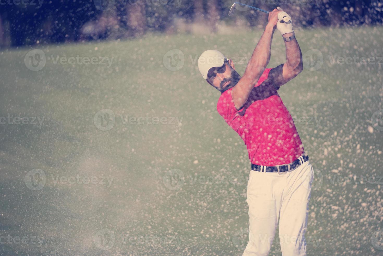 Golfspieler, der einen Sandbunkerschlag schlägt foto