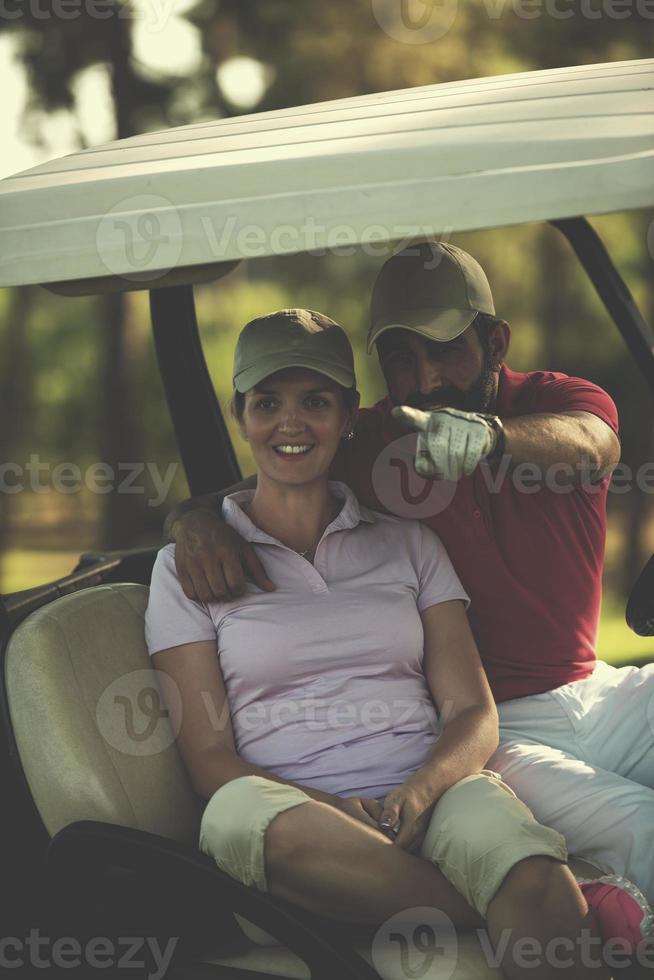 Paar im Buggy auf dem Golfplatz foto