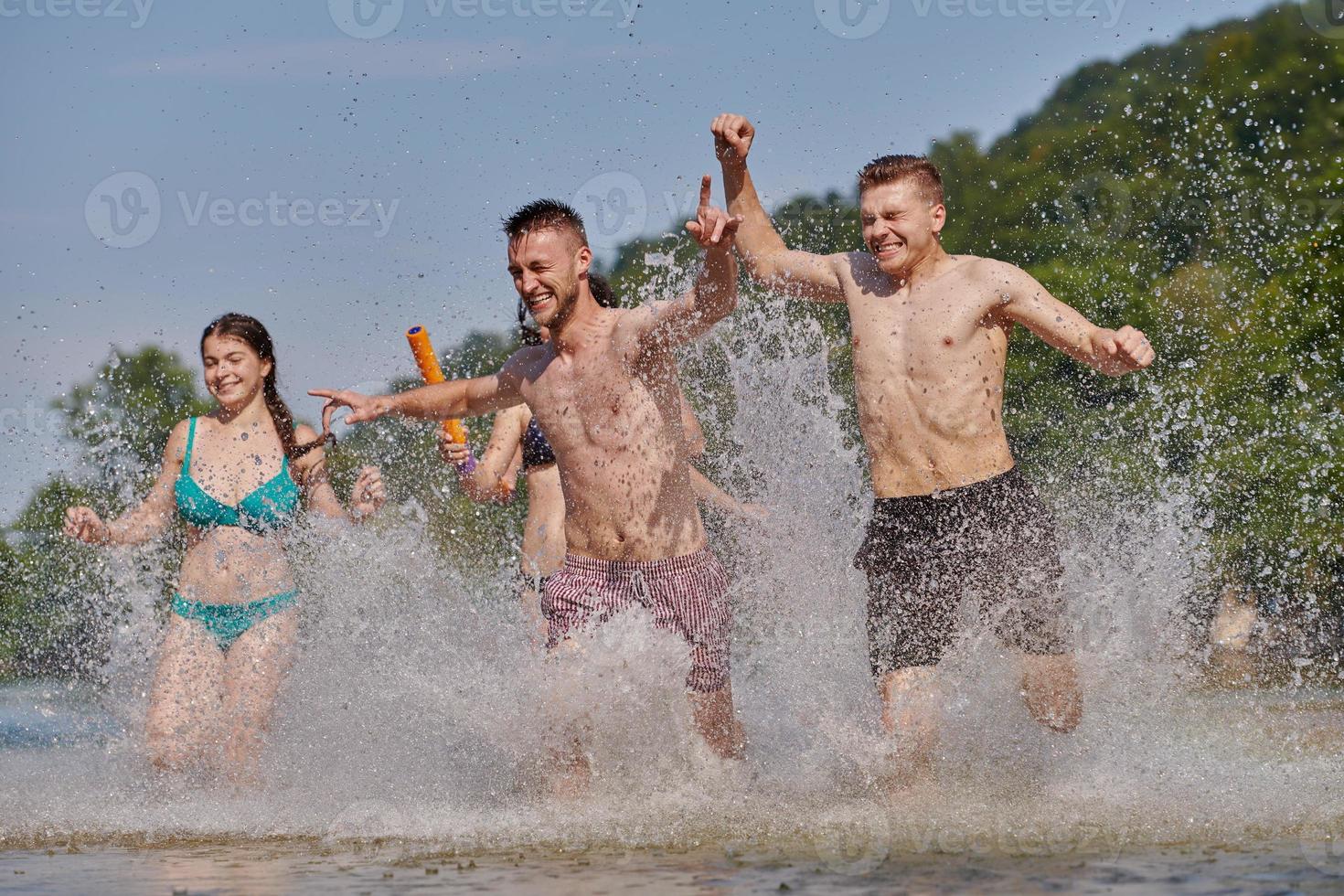 gruppe glücklicher freunde, die spaß am fluss haben foto