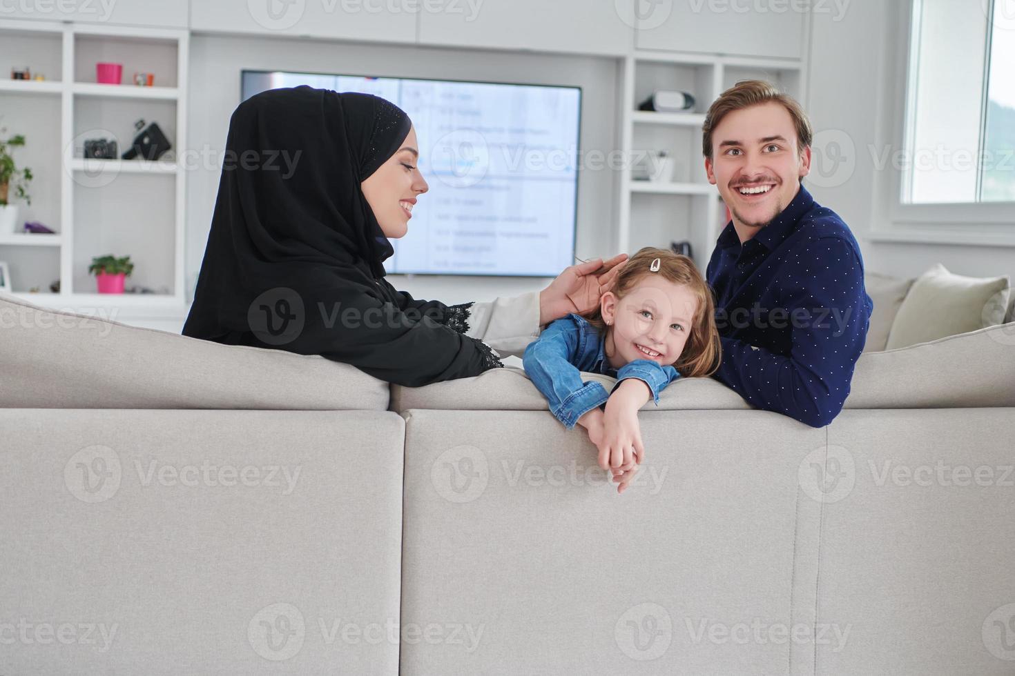 glückliche muslimische familie, die zeit zusammen in einem modernen haus verbringt foto