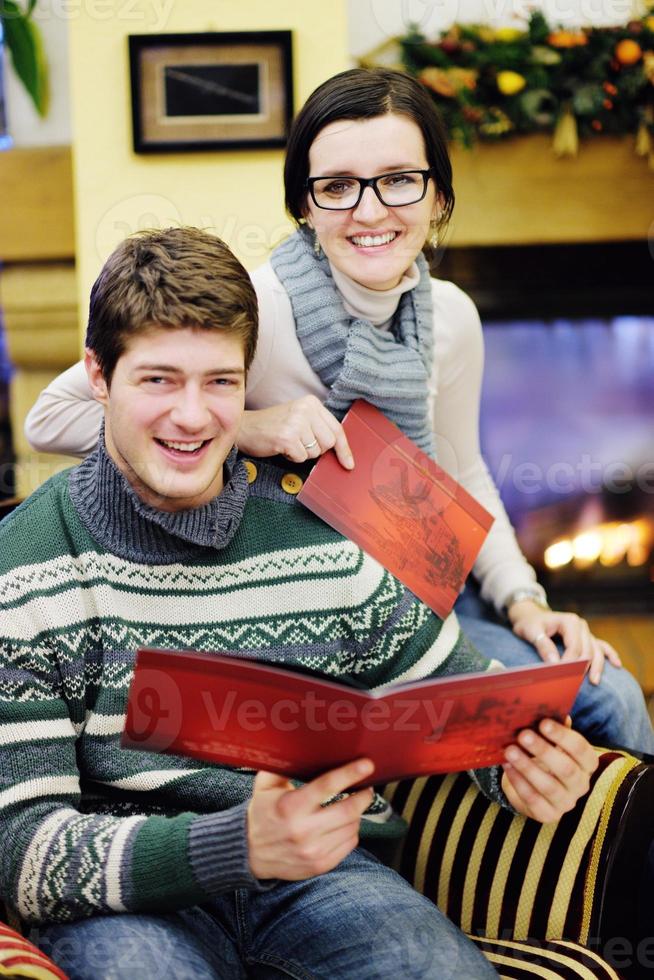 junges romantisches paar entspannen sich auf dem sofa vor dem kamin zu hause foto