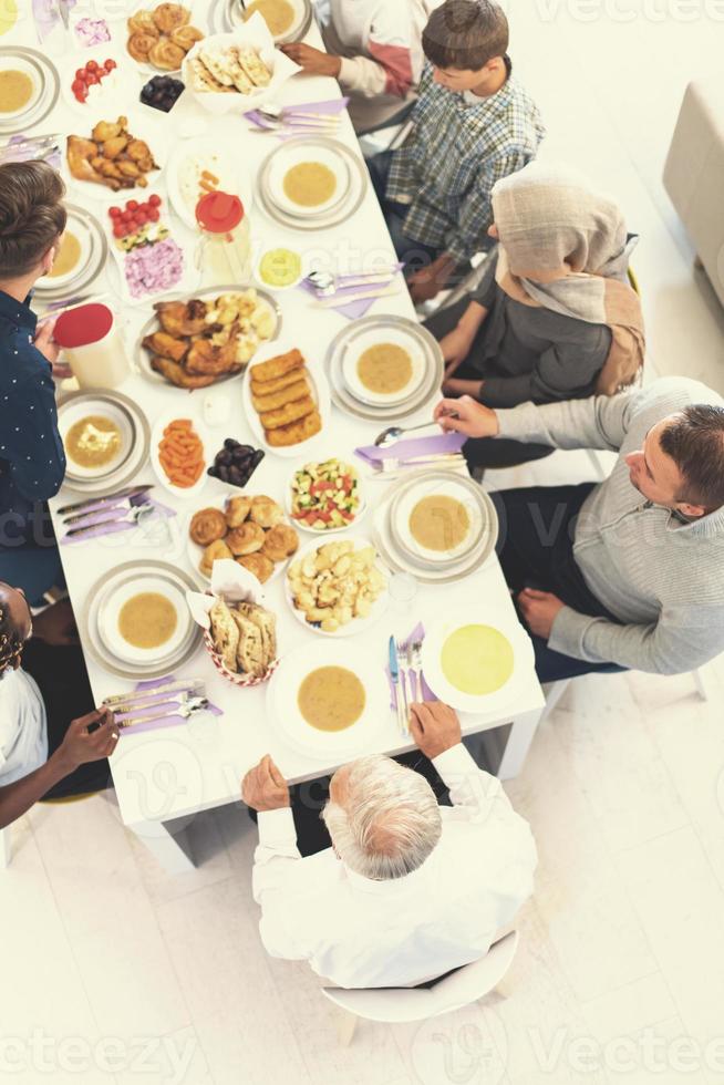 Draufsicht der modernen multiethnischen muslimischen Familie, die auf den Beginn des Iftar-Abendessens wartet foto