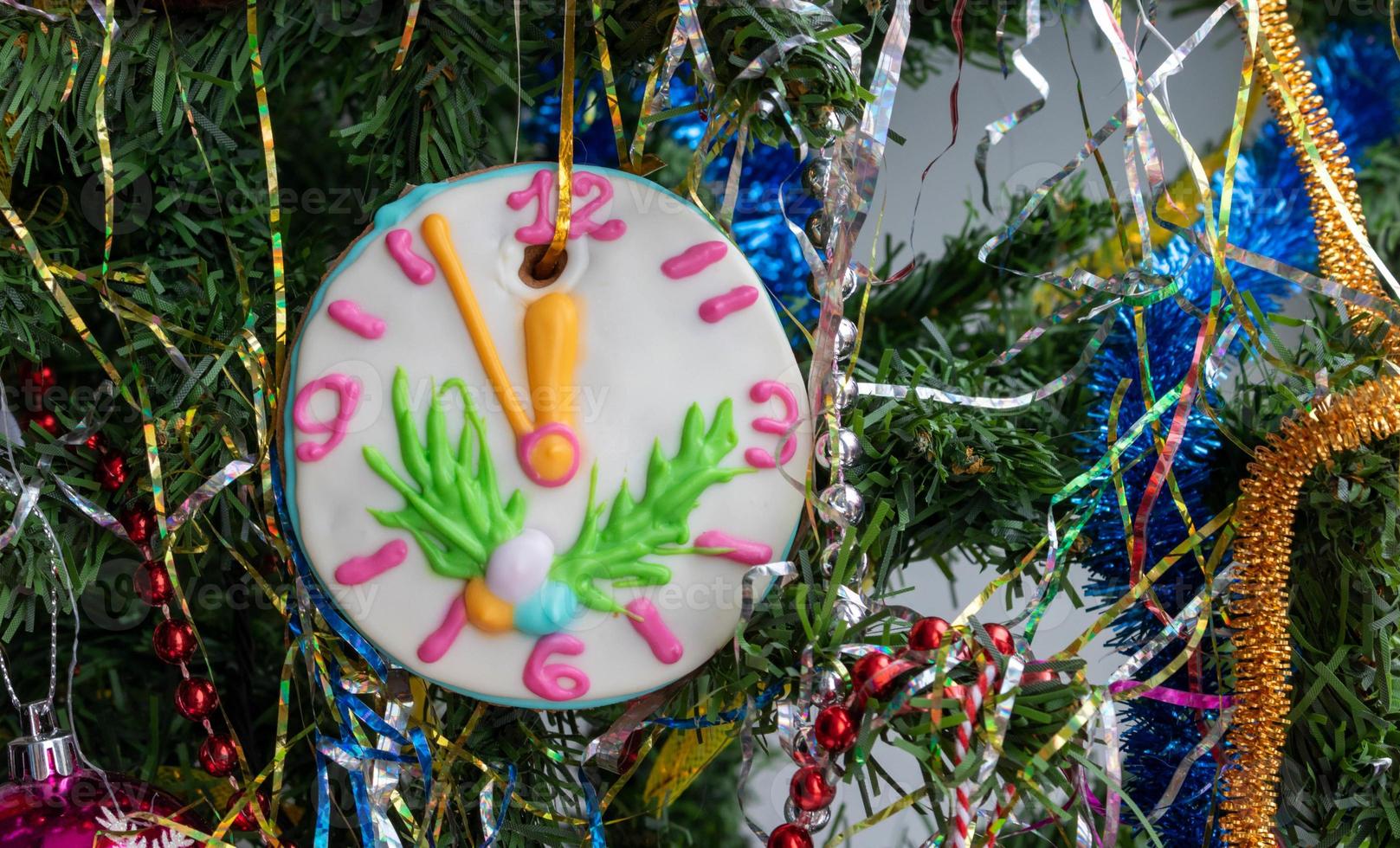 Nahaufnahme eines Weihnachtsbaums mit Ornamenten aus Kugeln, Schneeflocken, Lametta, Girlanden und einer großen Lebkuchenuhr foto
